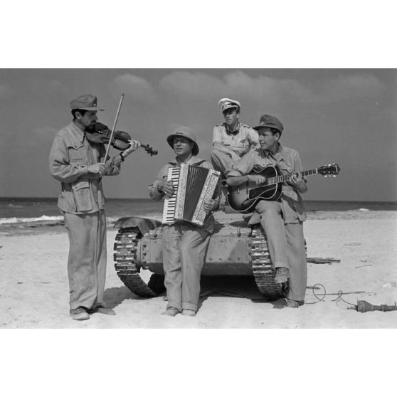 Sur une plage d'Egypte (El Quasaba), des membres de la KDF (Kraft durch Freude) jouent de la musique et chantent.