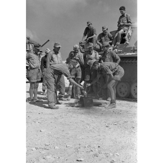 Repas de deux équipages de chars Panzer III progressant dans un désert égyptien.