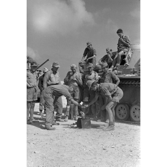 Repas de deux équipages de chars Panzer III progressant dans un désert égyptien.