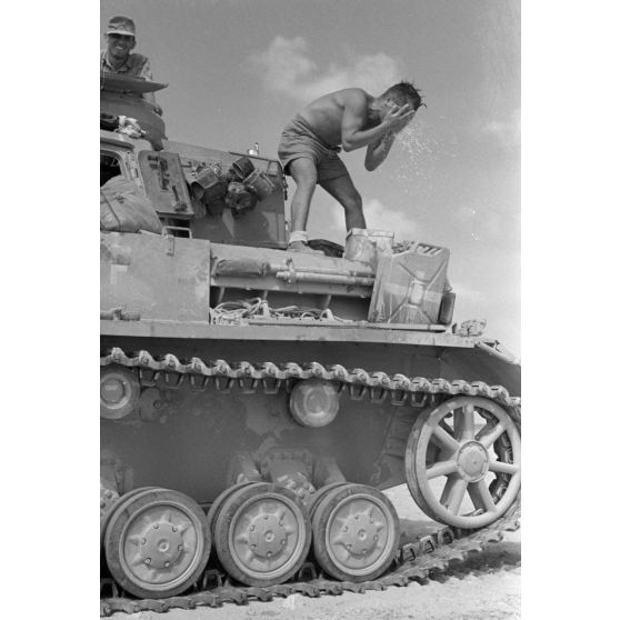 Dans un désert égyptien, la toilette d'un membre d'équipage de char Panzer III .