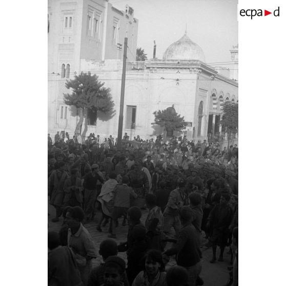 A Tunis, entouré par des enfants, un défilé de troupes aéroportées allemandes dans les rues.