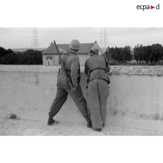 Deux parachutistes allemands sur un pont, à gauche un fusil Gewehr 41 et à droite un pistolet-mitrailleur MP-40.