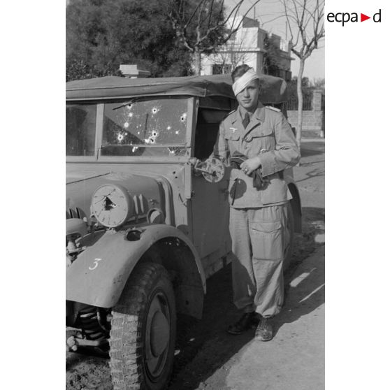 Portrait d'un sous-lieutenant (Leutnant) de la Luftwaffe au volant d'un véhicule dont le pare-brise est criblé d'impacts.