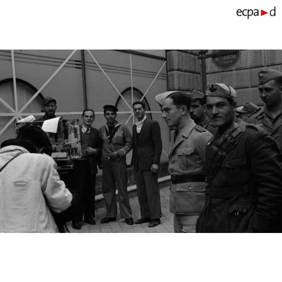 Un photographe de rue réalise des portraits de soldats allemands et italiens.