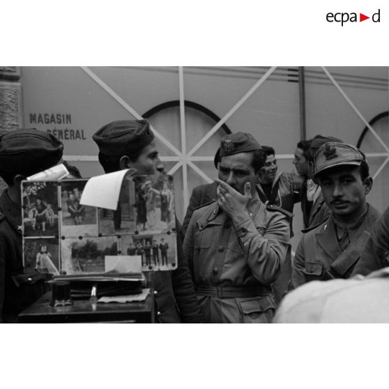 Un photographe de rue réalise des portraits de soldats allemands et italiens.