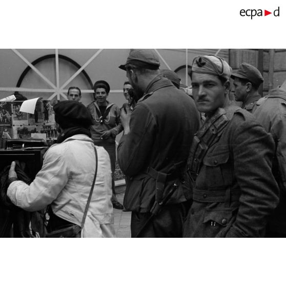 Un photographe de rue réalise des portraits de soldats allemands et italiens.