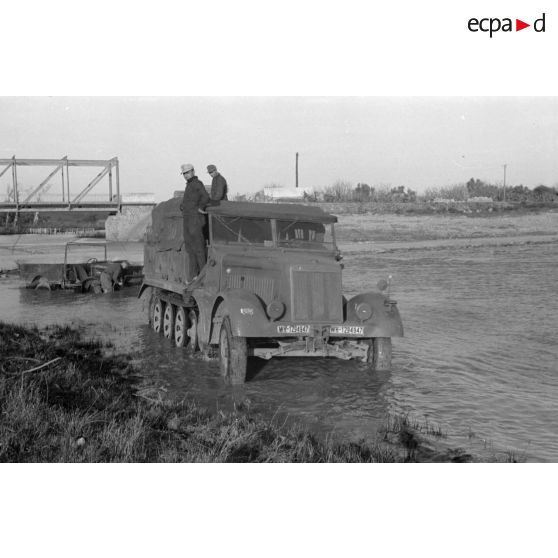 Dépannage d'un véhicule britannique par un semi-chenillé Sd.kfz.7, on note l'inscription Gruppe Hägele sur le blindé allemand.