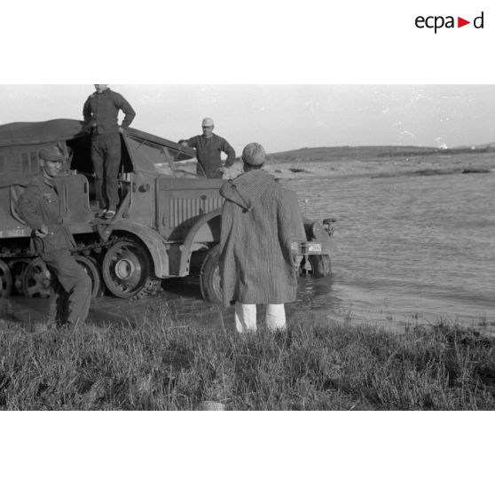 Dépannage d'un véhicule britannique par un semi-chenillé Sd.kfz.7, on note l'inscription Gruppe Hägele sur le blindé allemand.