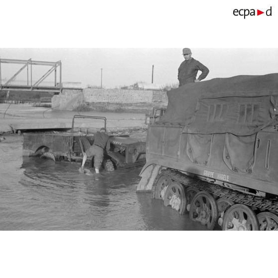 Dépannage d'un véhicule britannique par un semi-chenillé Sd.kfz.7, on note l'inscription Gruppe Hägele sur le blindé allemand.