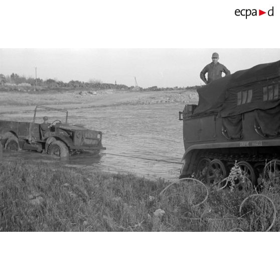 Dépannage d'un véhicule britannique par un semi-chenillé Sd.kfz.7, on note l'inscription Gruppe Hägele sur le blindé allemand.