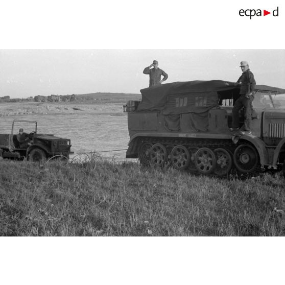 Dépannage d'un véhicule britannique par un semi-chenillé Sd.kfz.7, on note l'inscription Gruppe Hägele sur le blindé allemand.