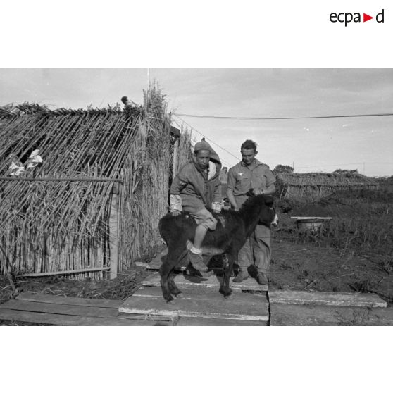 En Tunisie, la vie quotidienne de soldats de la Flak devant des abris de fortune.