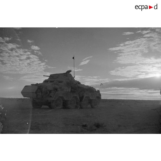 Un blindé SdKfz-231 roule dans le désert au crépuscule.