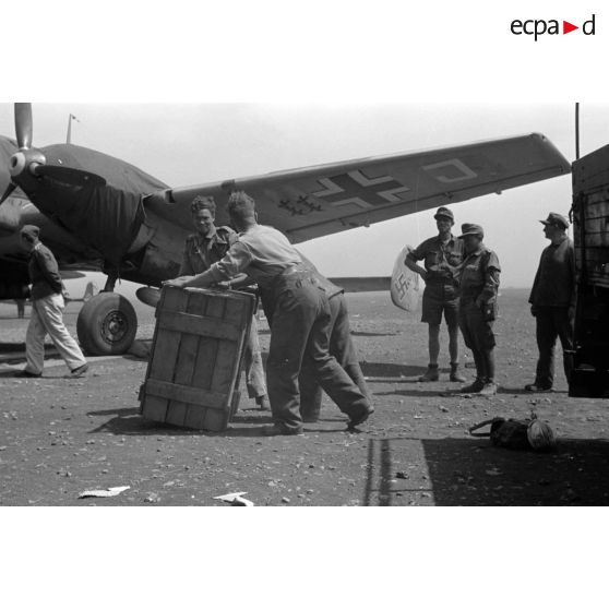 Un bimoteur Messerschmitt Bf-110 F1-R2 du Zerstörergeschwader 26 (ZG-26) sur un aérodrome de campagne. Déchargement de caisses.