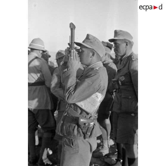 Un Oberleutnant de l'état-major de Rommel utilise un petit binoculaire pour observer le littoral.