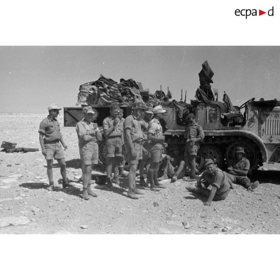 L'équipage d'une pièce de DCA de 8,8 cm FlaK ayant pris place dans le semi-chenillé Sd.kfz-8 qui tracte également le canon.