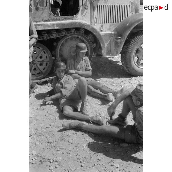 Les servants d'un canon de 8,8 cm FlaK allongés près de son SdKfz-8.