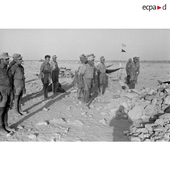 Des soldats au garde-à-vous à l'emplacement de ce qui semble être le poste de commandement de la position.