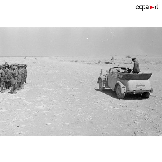 Rommel dans sa voiture Horch-Commandeur cabriolet passe devant une formation allemande au garde-à-vous.