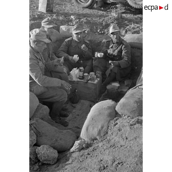 Un groupe de soldats mange dans un trou.