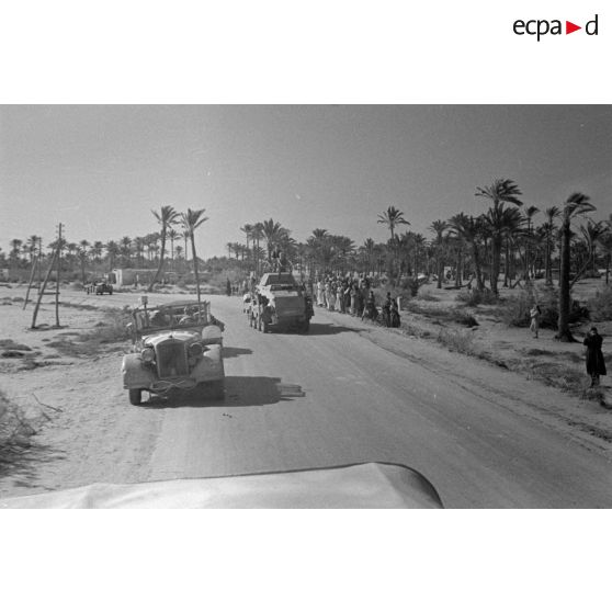 Des voitures Kfz-12 et Kfz-15 de l'Aufkl-Abt-3 et un blindé SdKfz-232 passent sur la route.