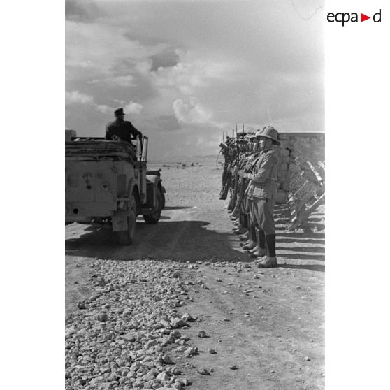 La garde d'honneur présente les armes à un officier allemand debout dans un véhicule Kfz-15.