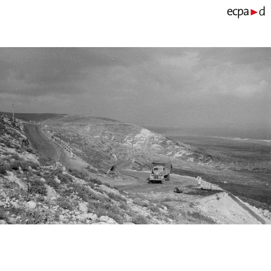 Un camion monte une côte sur une route, sûrement la via Balbia.