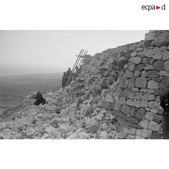 Au fort de Mechili, des soldats italiens reconstruisent un mur éboulé.