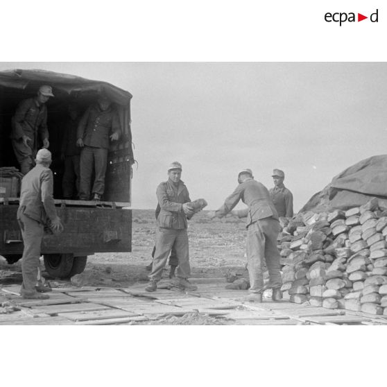 Des soldats déchargent un camion de pain.