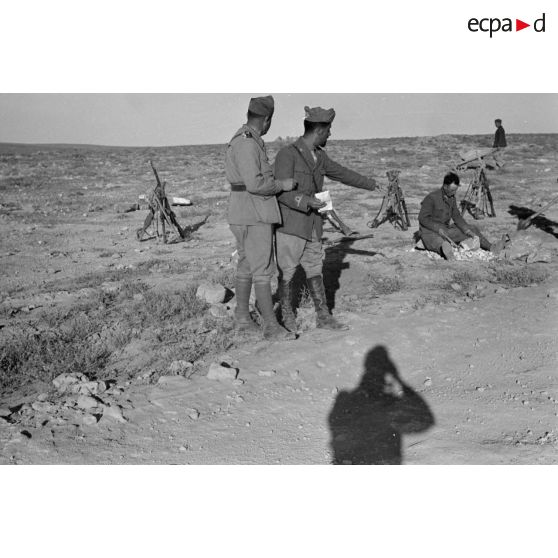 Un lieutenant et un sous-lieutenant dirigent les travaux de réfection d'une route.