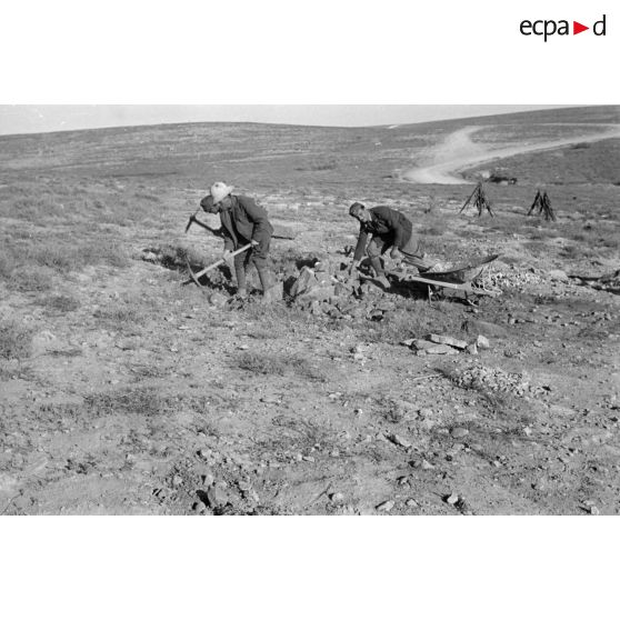 Des soldats italiens extraient des pierres (des pioches) qui seront utiles pour la réfection d'une route.