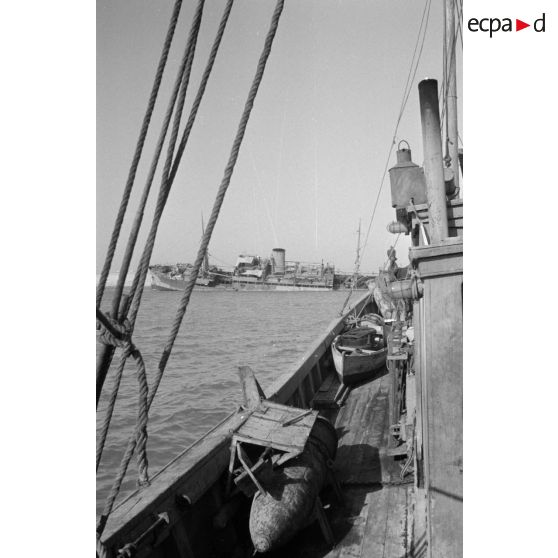 Des soldats italiens mangent sur le pont d'un bateau.