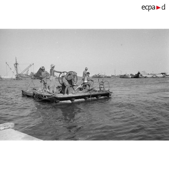 Travail d'une équipe autour d'un scaphandrier allemand qui plonge dans les eaux du port.