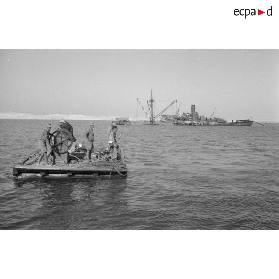 Travail d'une équipe autour d'un scaphandrier allemand qui plonge dans les eaux du port.