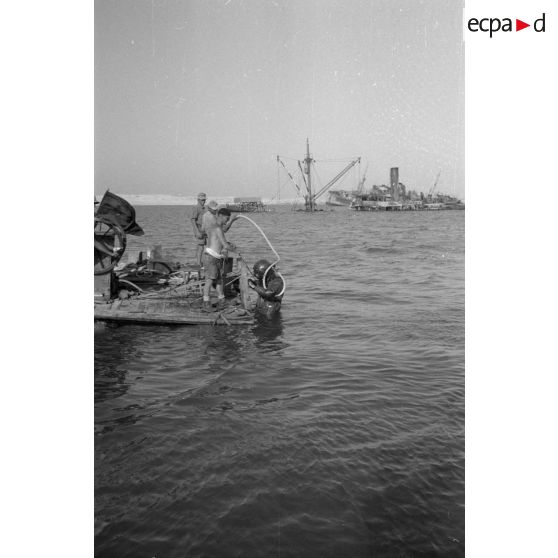 Travail d'une équipe autour d'un scaphandrier allemand qui plonge dans les eaux du port.