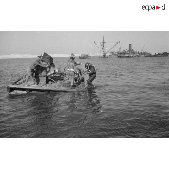 Travail d'une équipe autour d'un scaphandrier allemand qui plonge dans les eaux du port.