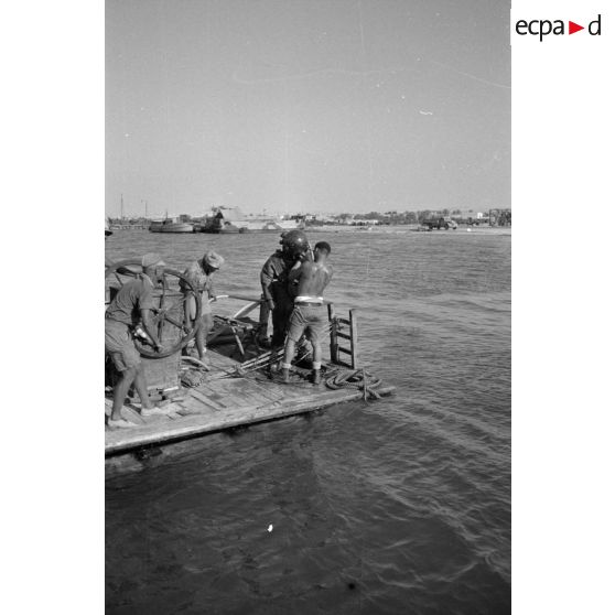 Travail d'une équipe autour d'un scaphandrier allemand qui plonge dans les eaux du port.