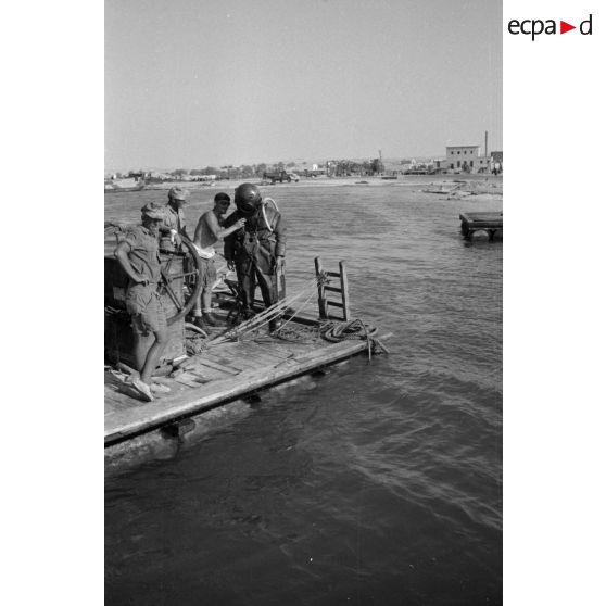 Travail d'une équipe autour d'un scaphandrier allemand qui plonge dans les eaux du port.