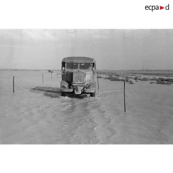 Un camion italien Lancia traverse une piste inondée.