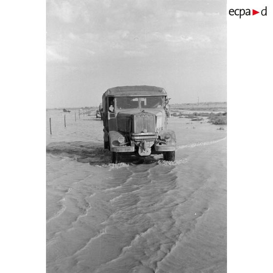 Un camion italien Lancia traverse une piste inondée.