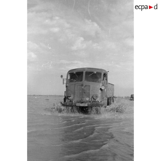 Un camion italien traverse une route inondée.