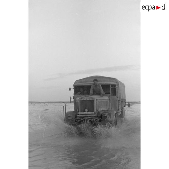 Un camion italien Lancia traverse une piste inondée.