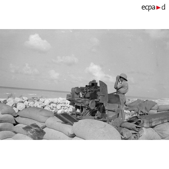 Alvéole d'un canon FlaK-38 de 2 cm, un des servants scrutant la mer avec des jumelles.