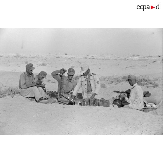 Chargement des munitions pour une mitrailleuse MG-34 au sein d'une position défensive allemande.