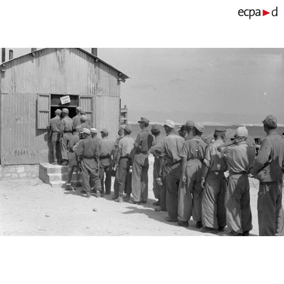 Des soldats font la queue pendant une distibution de nourriture.