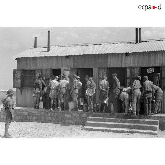 Des soldats font la queue pendant une distibution de nourriture.