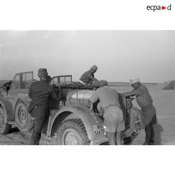 Le colonel (Oberstleutnant) Panzenhagen monte dans une voiture Kfz-15 qui a des problèmes mécaniques.