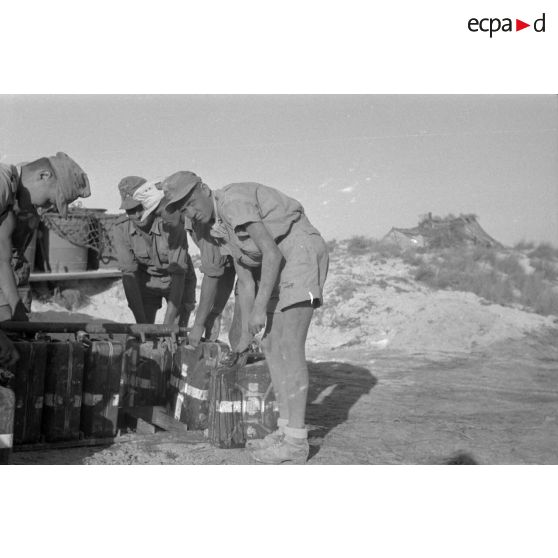 Des soldats remplissent des jerrycans d'eau potable.