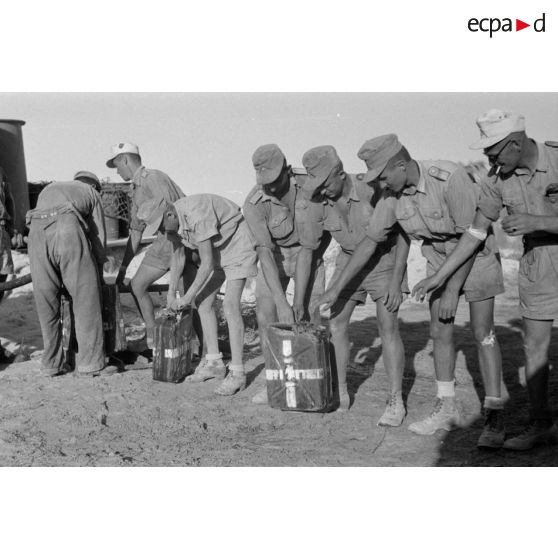 Des soldats remplissent des jerrycans d'eau potable.