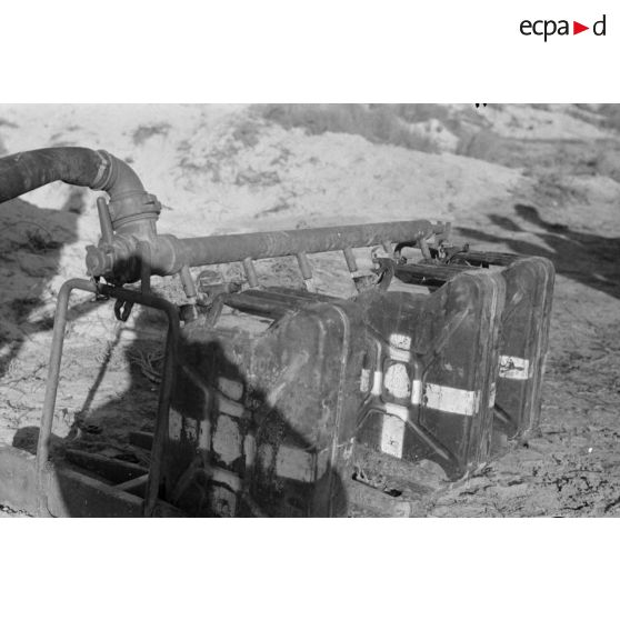 Des soldats remplissent des jerrycans d'eau potable.